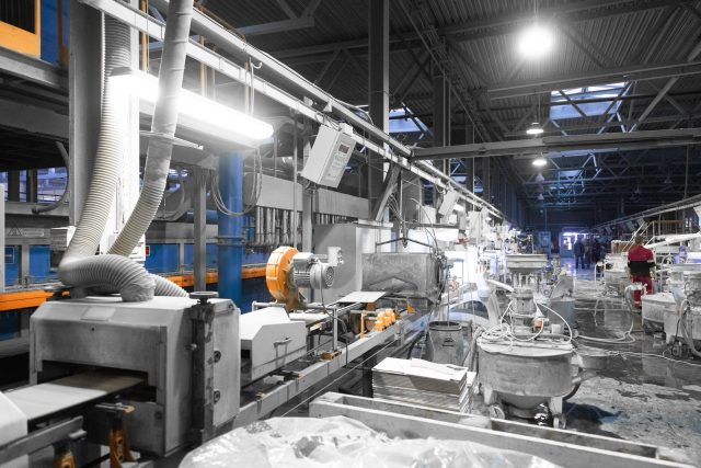 Cement factory interiors. Industrial cement production conveyor. Workers in the shop on the production line